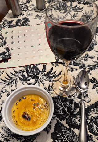 a glass of wine and a creme brulee